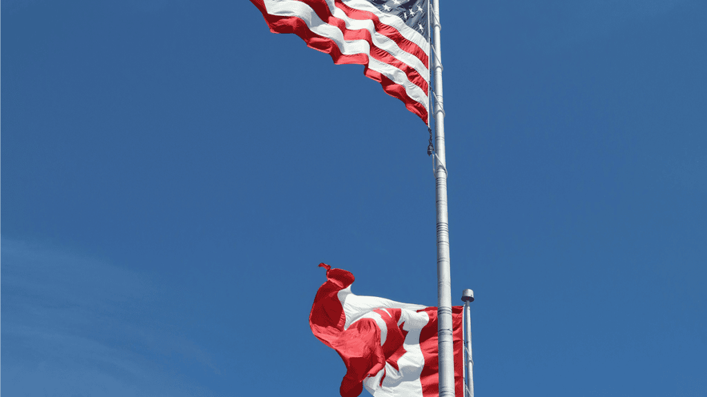 US and Canada flags on poles